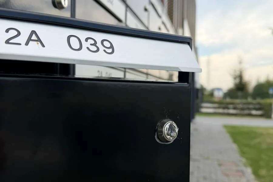 Geopende brievenbus met beschadigd slot in een brievenbussenpaneel