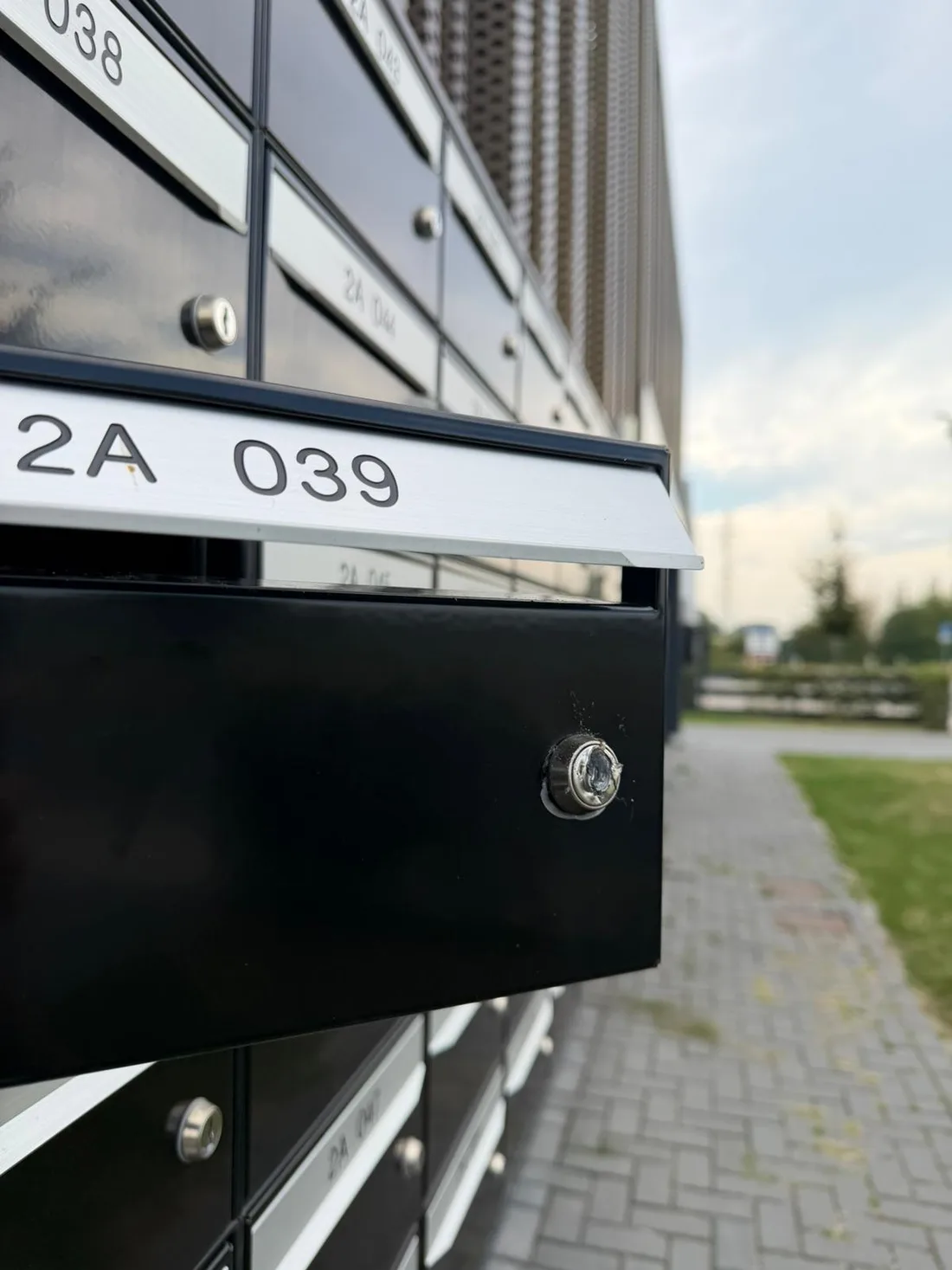 Geopende brievenbus met beschadigd slot in een brievenbussenpaneel