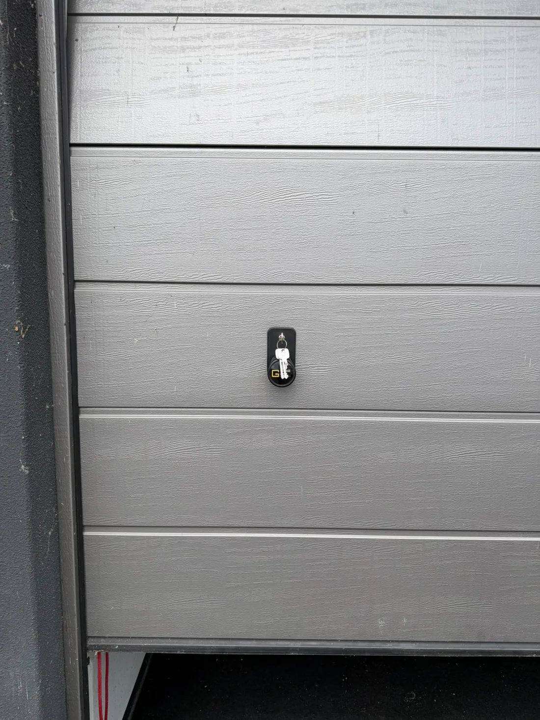 Grijze garagedeur met sleutel in het slot