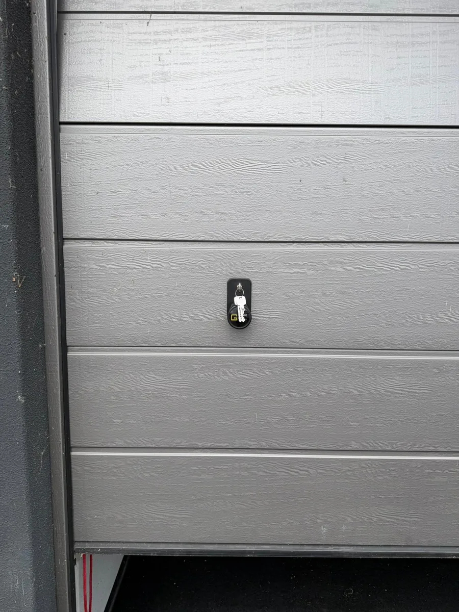 Grijze garagedeur met sleutel in het slot